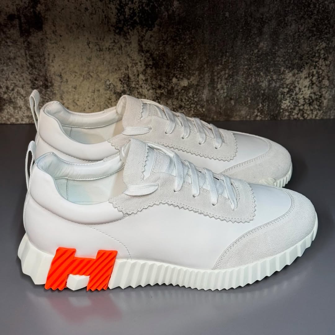 Hermés Bouncing Sneakers in a White Colorway with an Orange H Logo On The Sole